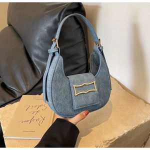 Detail van de lichtblauwe denim hobo tas met een unieke golvende gouden metalen gesp