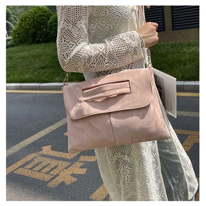 Gros plan détaillé d'un sac à bandoulière rose avec texture plissée en extérieur