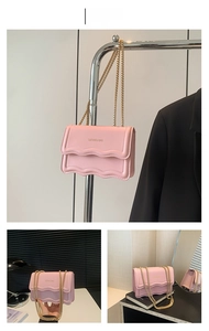 Detail of pink chain crossbody bag featuring a scalloped flap and gold metal strap