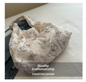 Close-up of textured butterfly floral canvas tote bag on denim jacket background