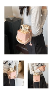 Pink cube bucket bag with pearl handle and golden chain strap detail view