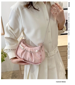 Pink pleated cloud bag with elegant pearl strap and silver chain in fashion setting