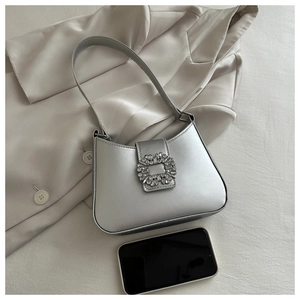 Detail of silver metallic underarm bag with crystal buckle and smartphone size reference