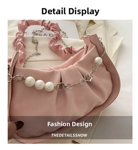 Detailed close-up of pink satin cloud bag with pearl chain and ruched shoulder strap