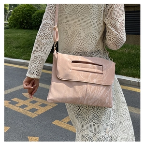 Détail du sac bandoulière en cuir PU rose pêche avec chaîne et poignée ajourée
