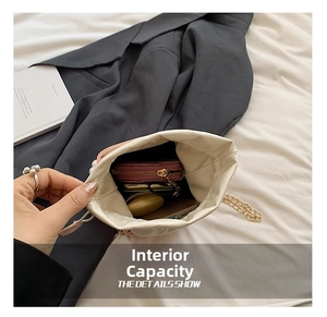 Capacité interne du sac seau blanc montrant téléphone, portefeuille et bijoux