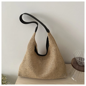 Detail of beige woven tote bag featuring black leather straps and intricate mesh texture