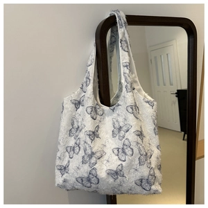 Detail shot of the soft blue floral pattern and plush faux fur texture of the tote bag