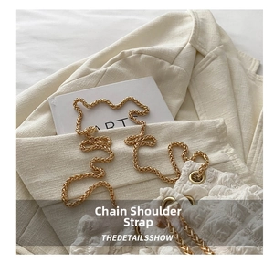 Detail of white bubble texture bucket bag featuring elegant gold metal chain strap