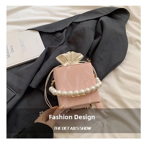 Détail du sac à main rose marbré avec poignée en perles et clous de fond dorés