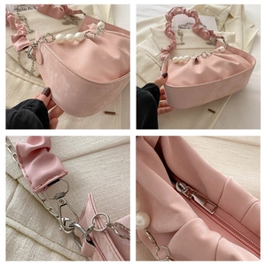 Detail view of pink satin cloud bag with pearl chain and elegant pleated texture
