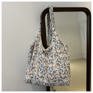 Detailed close-up of floral pattern on canvas tote bag hanging on a dark wood frame