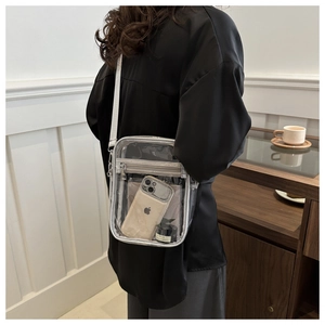 Detailed close-up showing the clear PVC shoulder bag with silver trim and front zipper pocket