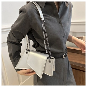 Close-up of a trendy silver irregular shoulder bag with chic metal chain strap