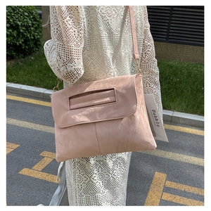 Detailed macro view of the ruched texture and hollow handle on this light pink PU handbag