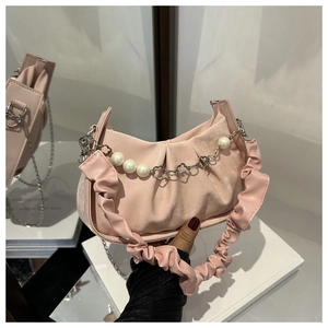 Detail of pink pleated handbag featuring silver floral chain and large pearl ornaments