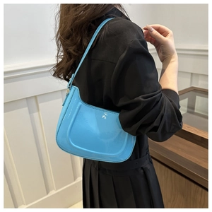 Close-up of sky blue patent leather hobo bag showing smooth glossy texture and silver buckle