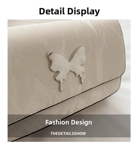 Close-up of cream wrinkled patent leather bag with a silver butterfly metal buckle detail
