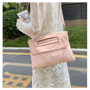 Détail du sac à bandoulière rose plissé avec bandoulière fine porté par un mannequin