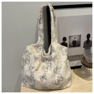 Detailed macro view of floral tote bag with fringe texture and grey butterfly pattern