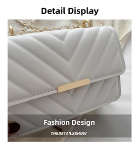 Nahaufnahme der weißen V-Stepptasche mit goldener Kette und metallischen Verzierungen