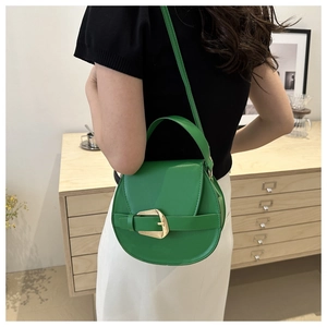 Detail of emerald green leather saddle bag featuring gold buckle and elegant strap