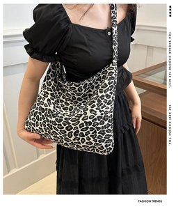 Detail shot of leopard print canvas shoulder bag with textured fabric on female model