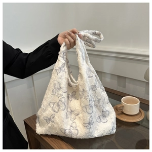 Detail of floral tote bag with textured knit fabric and blue butterfly pattern