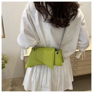 Détail du sac à bandoulière géométrique vert citron avec chaîne argentée sur le mannequin