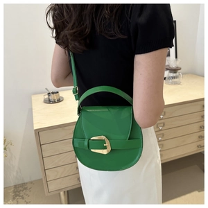 Detailed view of a green chain saddle bag with gold buckle in a cozy lifestyle setting