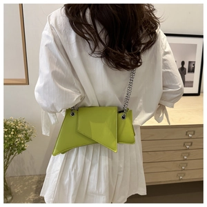 Détail d'un sac à bandoulière en cuir verni vert fluo avec chaîne argentée chic