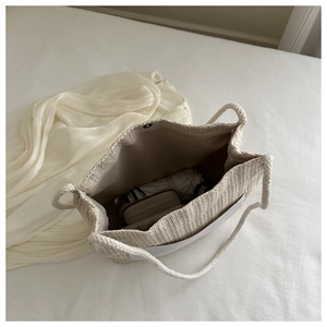 Spacious woven tote bag interior showing everyday essentials and metal magnetic buckle