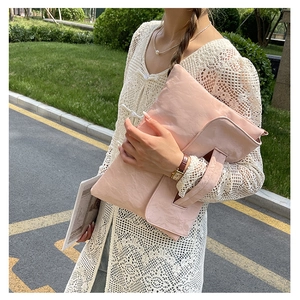 Detailed texture of pink pleated leather on a large crossbody envelope laptop bag