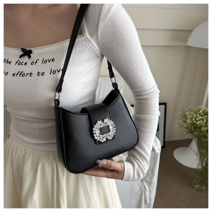 Detail of a chic black underarm bag featuring a luxury sparkling square rhinestone buckle