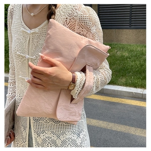 Pink pleated texture handbag showing large capacity and unique glossy material detail