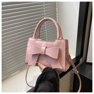 Close-up of pink fashion handbag with a large bow detail and round top handle