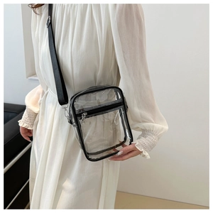 Detail view of transparent PVC crossbody bag with black trim and adjustable shoulder strap