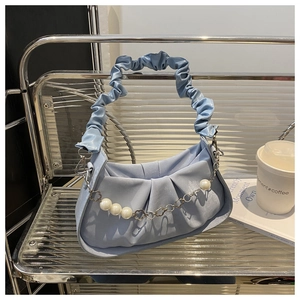 Close-up of light blue pleated bag with pearl chain and floral metal buckle detail