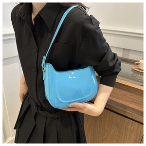 Close-up of light blue patent leather shoulder bag with glossy mirror finish