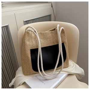 Detail of woven tote bag with herringbone texture and black pocket on a cozy chair