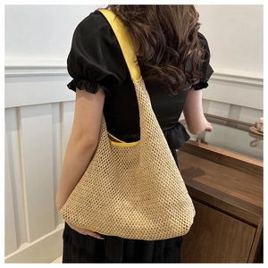 Close-up of beige woven tote bag with vibrant yellow shoulder strap and textured weave