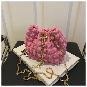 Dettaglio borsa a secchiello rosa con trama a bolle, catena dorata e coulisse con perle