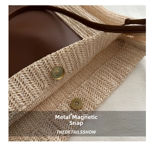 Close-up of magnetic snap closure on beige straw tote bag with brown leather trim