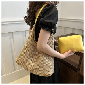 Detail of woven straw tote bag and yellow faux leather zipper pouch set with shoulder strap