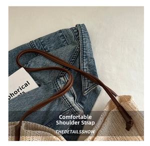 Detail shot of the knotted brown shoulder strap on a beige woven straw tote bag