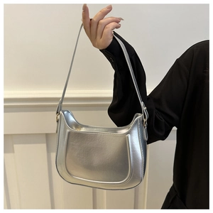 Close-up of a metallic silver half-moon bag featuring unique U-shaped embossed details