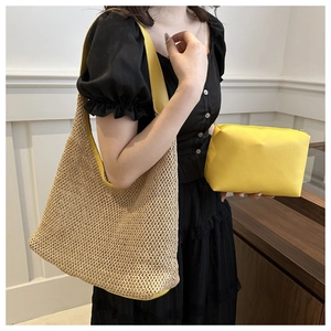 Detail of summer straw woven shoulder bag with yellow leather straps and inner pouch
