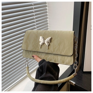 Detail of light green pleated crossbody bag with silver butterfly buckle and chain strap