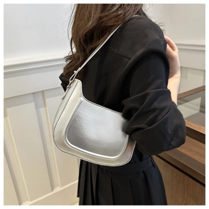 Silver metallic shoulder bag with smooth glossy finish on a black outfit