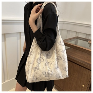 Detailed side view of white canvas tote bag with grey butterfly print and plush texture